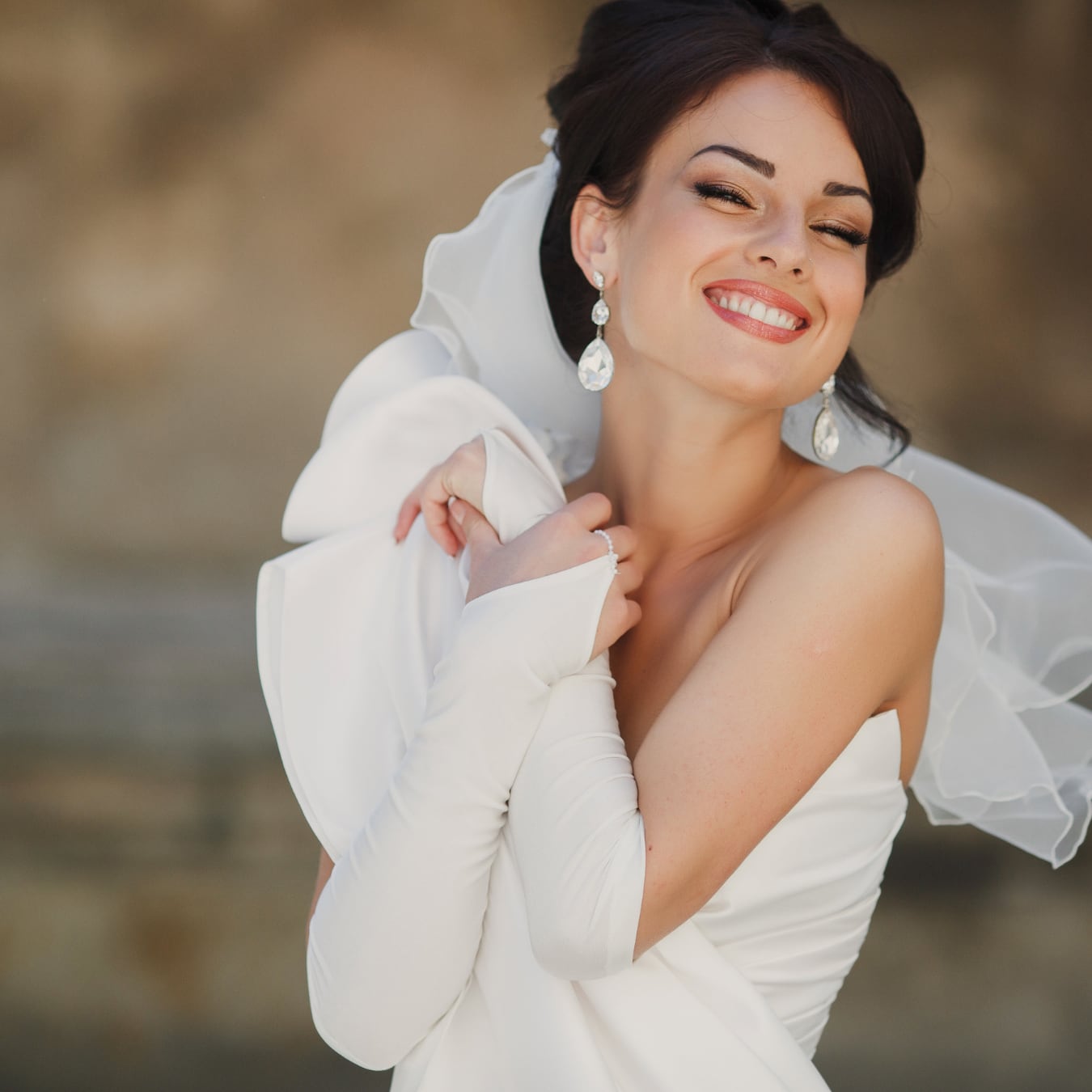 Smiling bride in a white wedding dress and veil