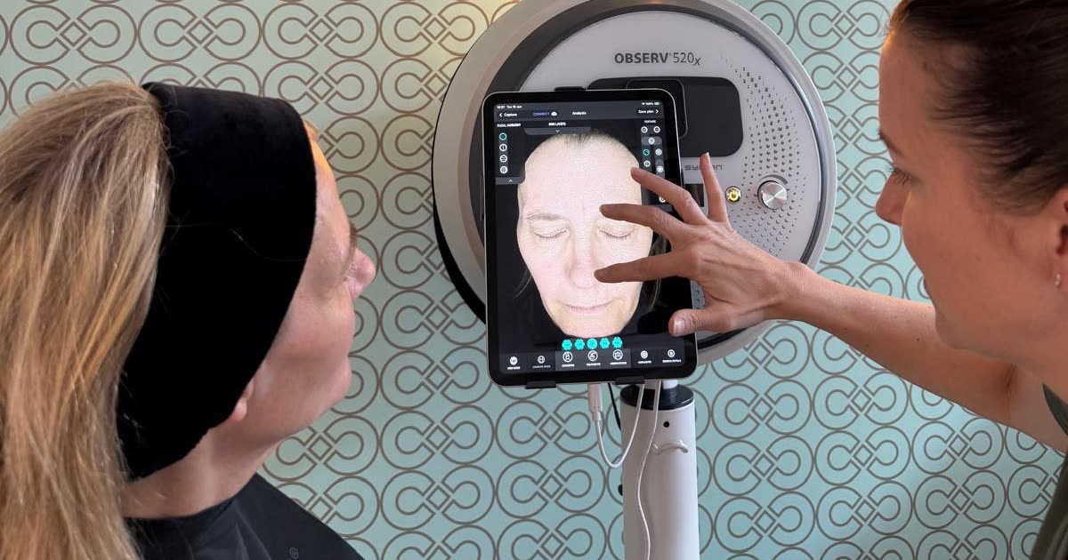 A Forever Facial Aesthetics skin expert showing a client her OBSERV 520x skin analysis