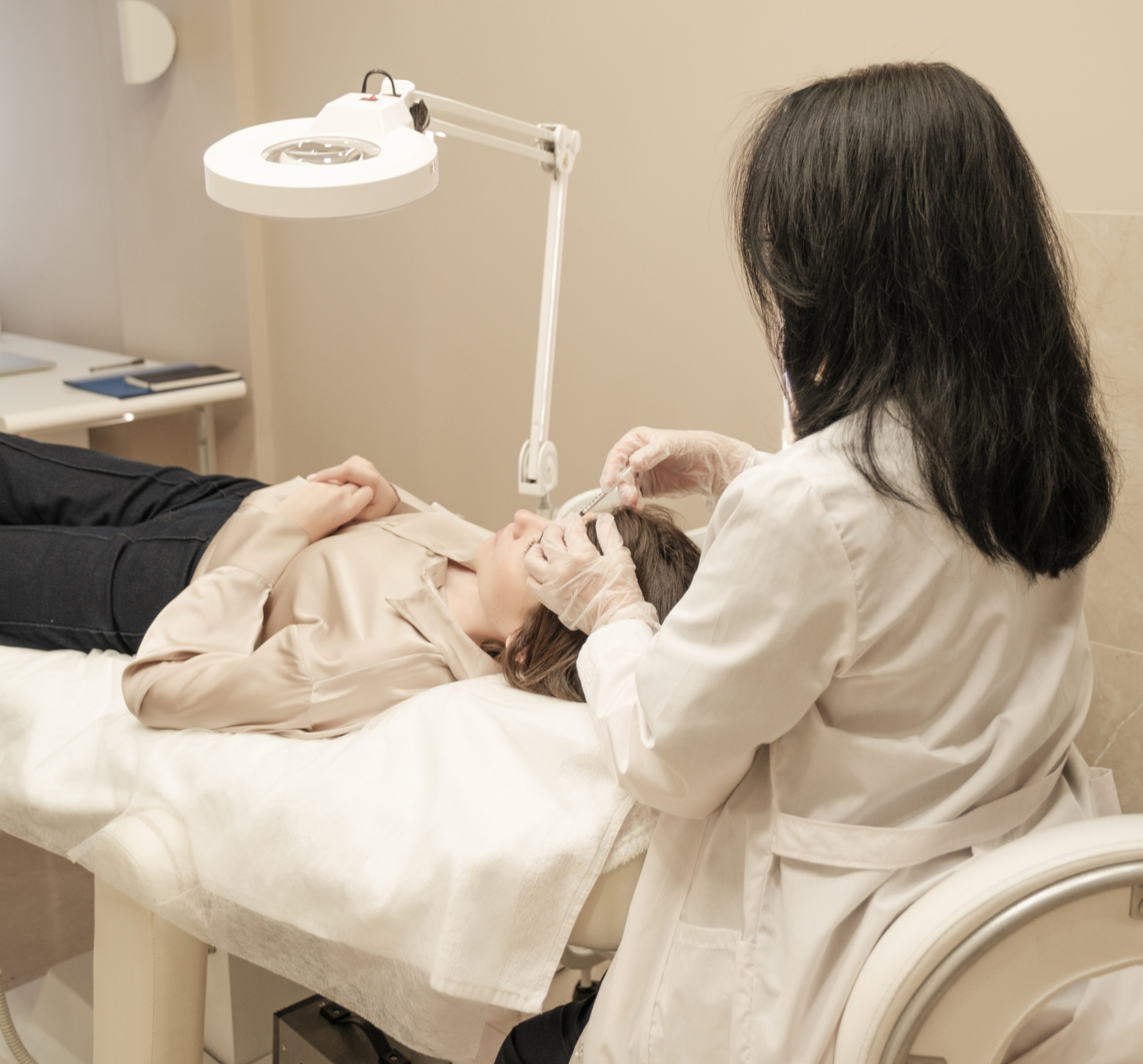 Aesthetic practitioner carrying out a facial treatment in a clinical treatment room