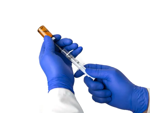 Gloved practitioner drawing up a vitamin injection from a vial