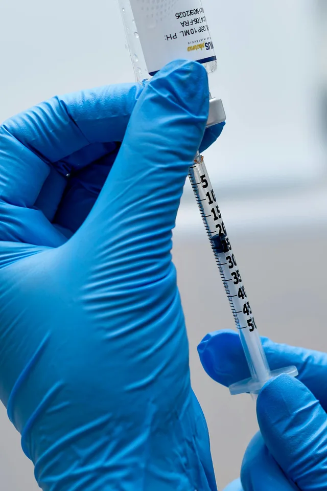 Practitioner preparing a vitamin injection